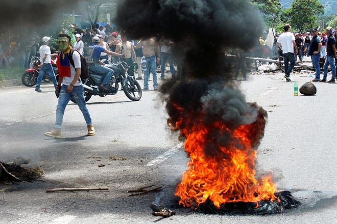 Người biểu tình phản đối ông Maduro ở thành phố San Cristobal của Venezuela. Đã có khoảng 120 người bị thương và gần 150 người bị bắt giữ trong các cuộc biểu tình ở Venezuela ngày 26/10 - Ảnh: Reuters.