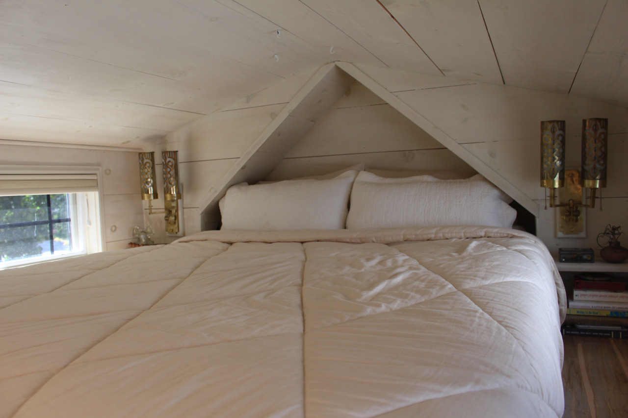 Góc nghỉ ngơi tuy nhỏ nhưng luôn tràn ngập ánh sáng tự nhiên nhờ những ô cửa sổ bằng kính ở hai bên giường ngủ.