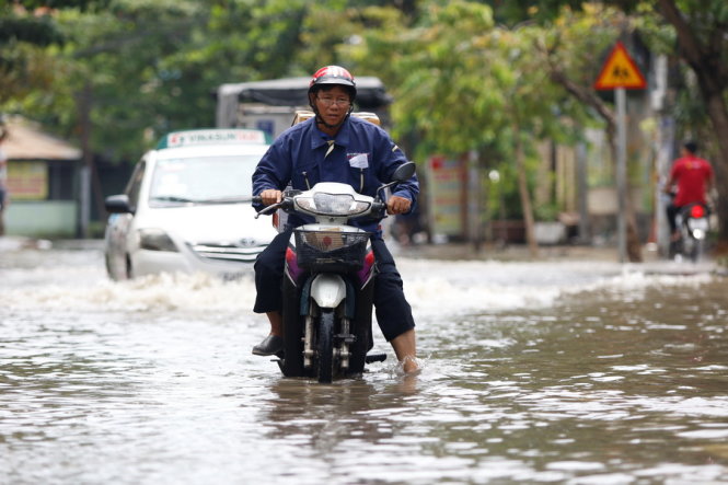 Xe của một người bị giao hàng bị chết máy tại đoạn ngập trên đường Quốc Hương (Q.2) - Ảnh: LÊ PHAN