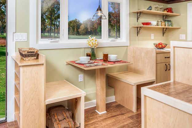 Ngay cạnh lối vào nhà là chiếc bàn gỗ nhỏ kế hợp vơi những chiếc ghế tích hợp tủ đựng đồ. Chiếc bàn nhỏ cạnh cửa sổ thoáng mát này vừa có thể làm không gian tiếp khách, là nơi làm việc và khi không dùng đến nó lại trở thành bàn ăn lý tưởng cho chủ nhà.