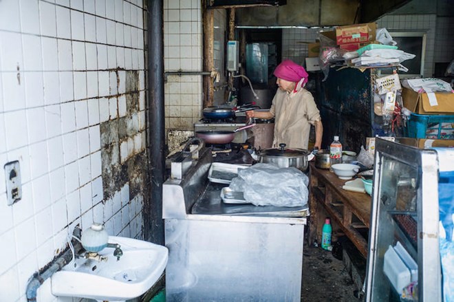 Cụ bà nấu ăn trong bếp.