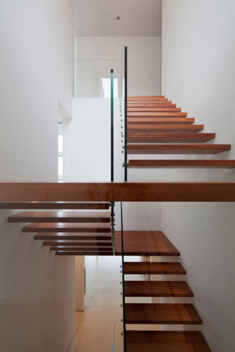 
Những bậc cầu thang gỗ màu kết hợp với bức tường trắng sáng tạo cảm giác hài hòa, thoải mái khi đi lại.
