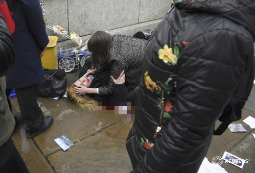 
Một phụ nữ bị thương nằm trên cầu Westminster sau vụ đâm xem liên hoàn. Ảnh: Reuters
