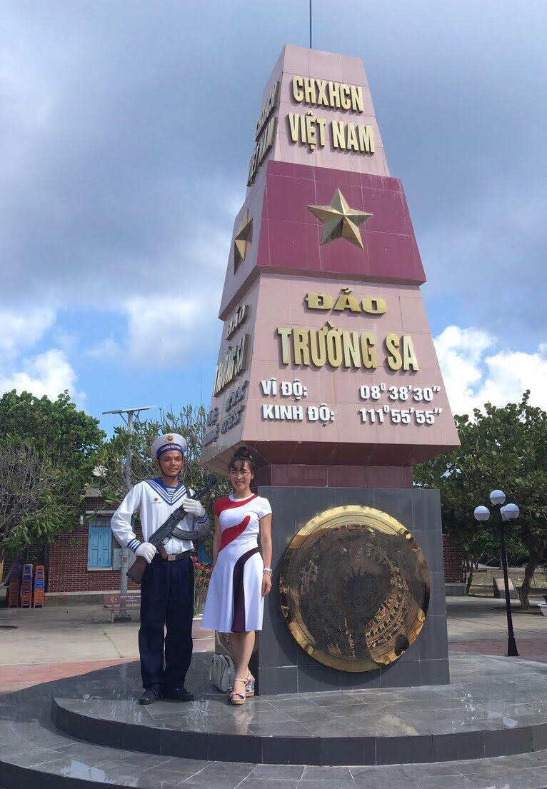 Bên cạnh cột mốc Trường Sa với bộ váy đi đường và đôi dép xăng đan
