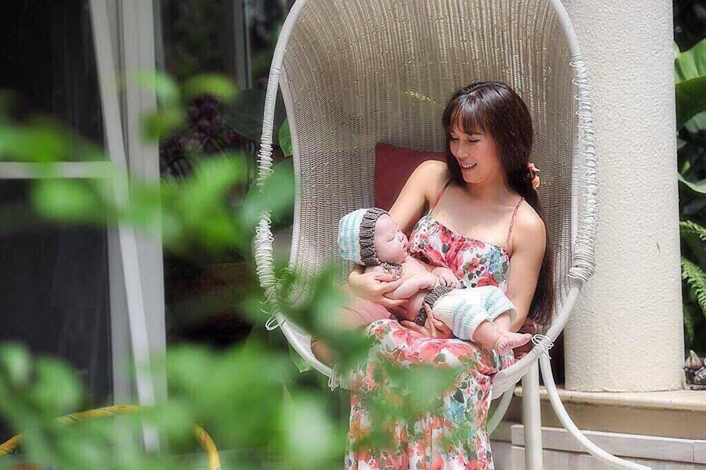 Dịu dàng bế con trai nhỏ trong bộ váy cotton và mái tóc mới gội đầu để buông dài