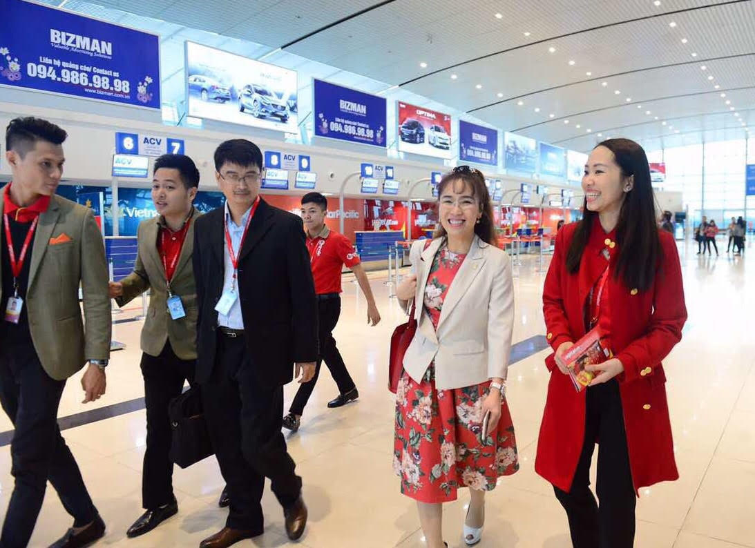 Áo vest trắng phối với váy hoa cùng nhân viên đi thị sát sân bay dịp cao điểm tết