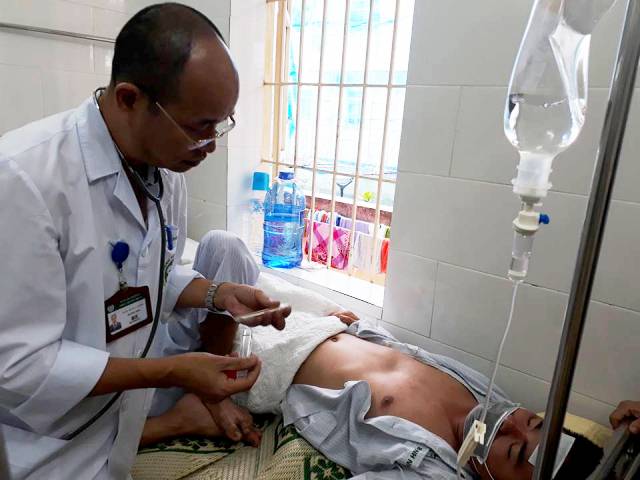 Bác sĩ kiểm tra nhiệt độ, thăm khám cho bệnh nhân sốt xuất huyết tại BV Bạch Mai.