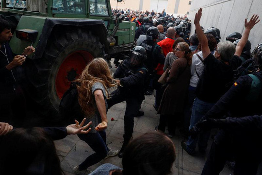 Cảnh sát chống bạo động tranh cãi với một người phụ nữ. Ảnh: REUTERS
