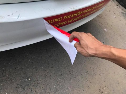 
Nhiều tài xế bức xúc, tự gỡ bỏ decal có nội dung phản đối Uber và Grab.
