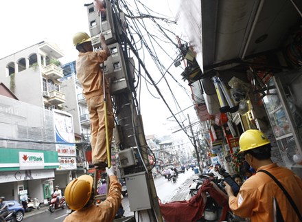 
Nhân viên Cty Điện lực Hà Nội ghi chỉ số công tơ điện của các hộ dân trên phố Khâm Thiên - Hà Nội. Ảnh: Như Ý.
