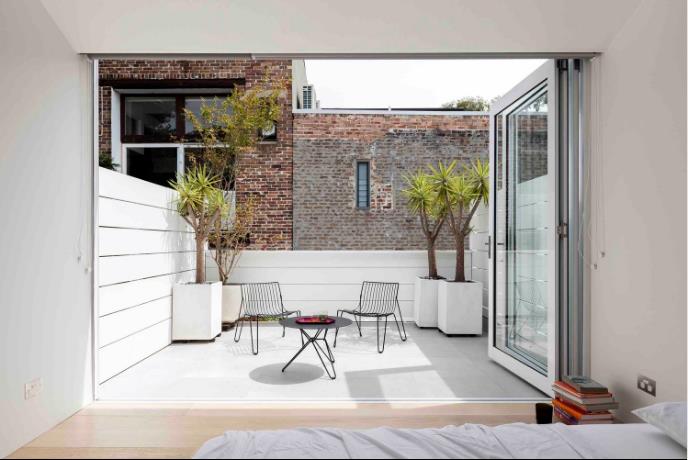 Phòng ngủ tuyệt đẹp nhìn ra khu vườn. Hai không gian này được ngăn cách bằng hệ cửa kính gấp để đóng mở khi cần.