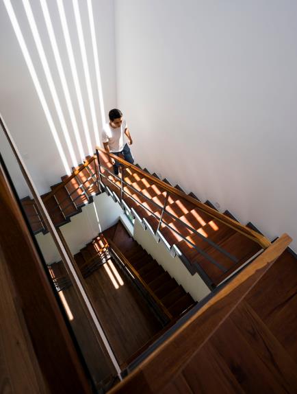 
Cầu thang gỗ ngập nắng là lối duy nhất dẫn lên tầng 2 và 3 của ngôi nhà.

 
