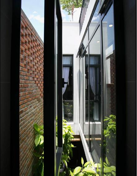 Cửa sổ kính mở ra khu giếng trời với nhiều cây xanh. Nhờ thiết kế thông minh này mà nằm trong phòng ngủ chủ nhà cũng có thể cảm nhận được từng sự biến đổi của thời tiết bên ngoài. 