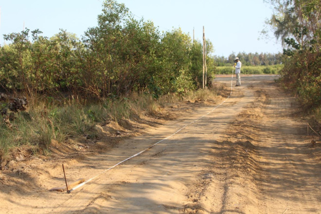 Một người dân Cần Giờ đang đo lại diện tích đất trên đường Duyên Hải, xã Long Hòa - trước đây là vườn trồng xoài - để chuẩn bị rao bán. Ảnh: V. Văn.