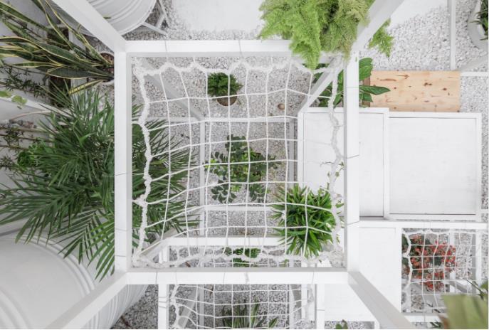 Ngoài những khung thép hình vuông được thiết kế đặc biệt đan xen nhau, mặt sàn khu ban công nhỏ còn được rải một lớp đá răm trắng.