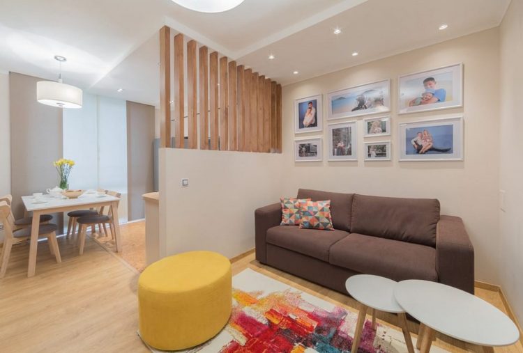 Phòng khách được bố trí đơn giản với chiếc sofa dài kê sát tường cùng bàn trà nhỏ.