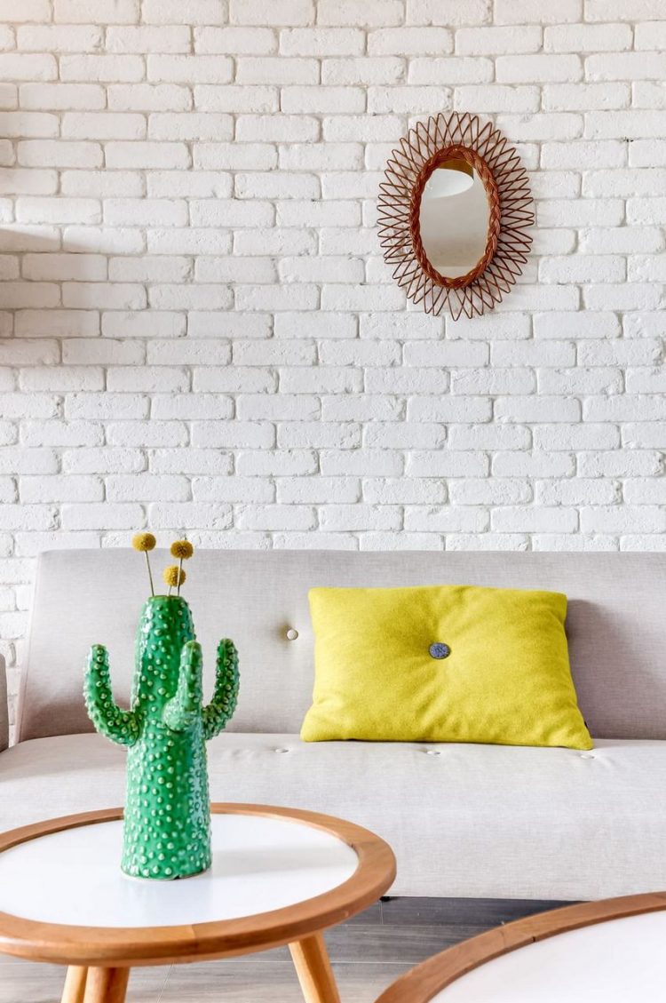 Góc nhỏ còn được nhấn nhá bằng rất nhiều những đồ trang trí màu sắc đẹp mắt như chiếc gối ôm tông vàng, chiếc gương treo tường và thậm chí cả cây xương rồng tuyệt đẹp trên bàn trà.