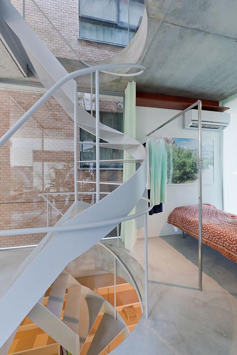  Chiếc cầu thang xoắn ốc tiết kiệm không gian được thiết kế khéo léo đi qua các lỗ tròn xuyên qua lớp sàn bê tông dày. 