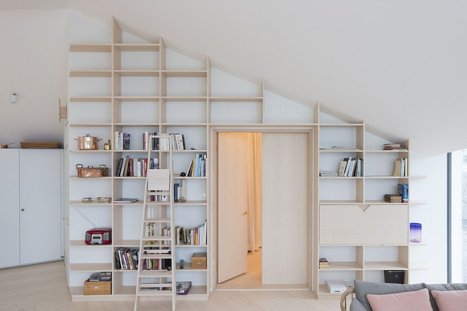 Một hệ kệ gỗ có kích thước rộng lớn cao sát trần nhà. Ẩn bên trong là một phòng nhỏ.