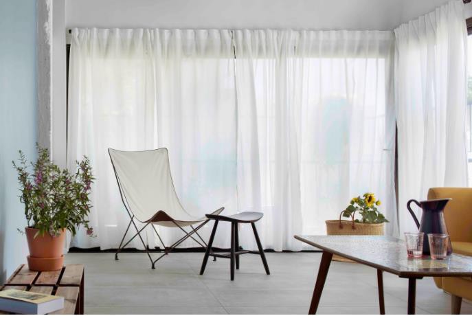 Khu vực sát cửa sổ chủ nhà dành riêng làm không gian thư giãn tuyệt đẹp với chiếc ghế bành cách điệu và hoa tươi. Không gian phòng khách tuy bé nhưng nhờ được thiết kế với tông màu trắng chủ đạo khiến không gian lúc nào cũng thoáng sáng và rộng rãi.