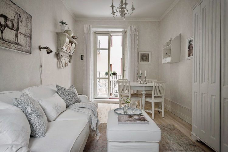 Phòng khách đơn giản với bộ salon kê sát tường để tiết kiệm diện tích và một bàn trà trắng muốt.