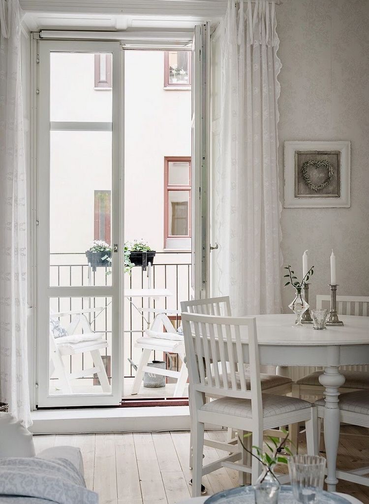 Ngay cạnh là bộ bàn ăn gỗ được trang trí lãng mạn với nến và cây xanh.