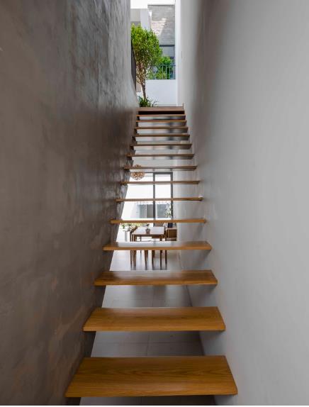 Cầu thang dẫn lên tầng được làm bằng gỗ đặt phía cuối nhà. 