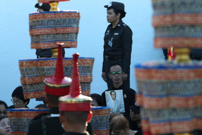 Một người đàn ông cầm di ảnh của cố vương Adulyadej trong buổi tập dượt. Ảnh: REUTERS