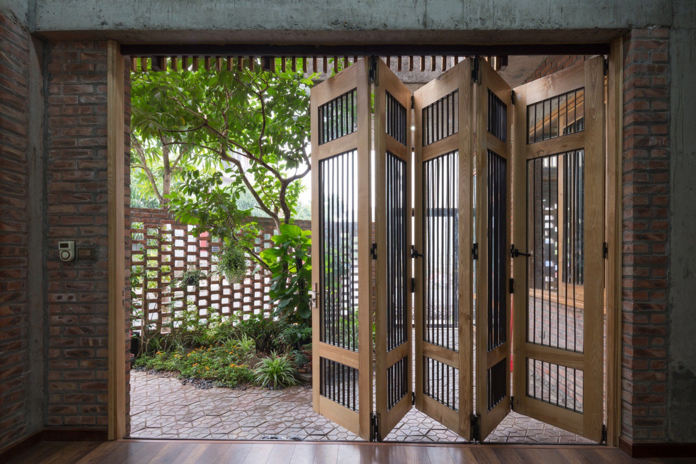 Hệ cửa lớn trước nhà được thiết kế gấp dễ đóng mở mà không hề tốn diện tích ngôi nhà.