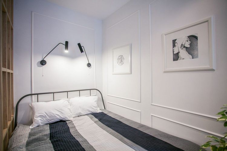 Góc nghỉ ngơi tương đối đơn thuần và tiện dụng mang hệ kệ gỗ ngay hông giường ngủ. Trên tường được trang trí bằng những bức chân dung đẹp mắt.