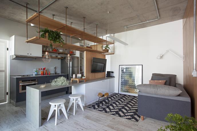 Bước chân vào căn hộ này, ấn tượng đầu tiên đó chính là giá treo bằng gỗ phân chia giữa không gian bếp và phòng khách.