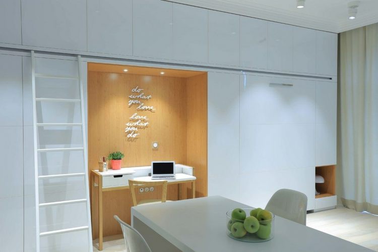 Chiếc tủ thông minh này được thiết kế dọc bức tường nhà với điểm nhấn là góc làm việc được trang trí bởi đèn điện và lớp phủ giả gỗ cùng những dòng chữ vô cùng lạ mắt.