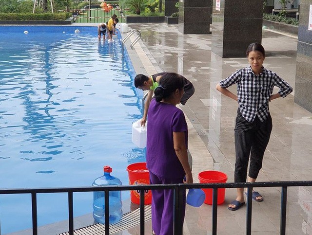  Cư dân mang quần áo giặt giũ, múc nước bể bơi để dùng trong cơn khát ở Hà Nội  - Ảnh 4.
