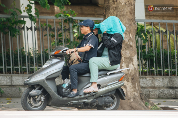 Ảnh: Nhiệt độ ngoài đường tại Hà Nội lên tới 50 độ C, người dân trùm khăn áo kín mít di chuyển trên phố - Ảnh 18.