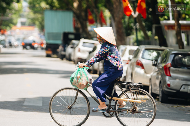 Ảnh: Nhiệt độ ngoài đường tại Hà Nội lên tới 50 độ C, người dân trùm khăn áo kín mít di chuyển trên phố - Ảnh 10.