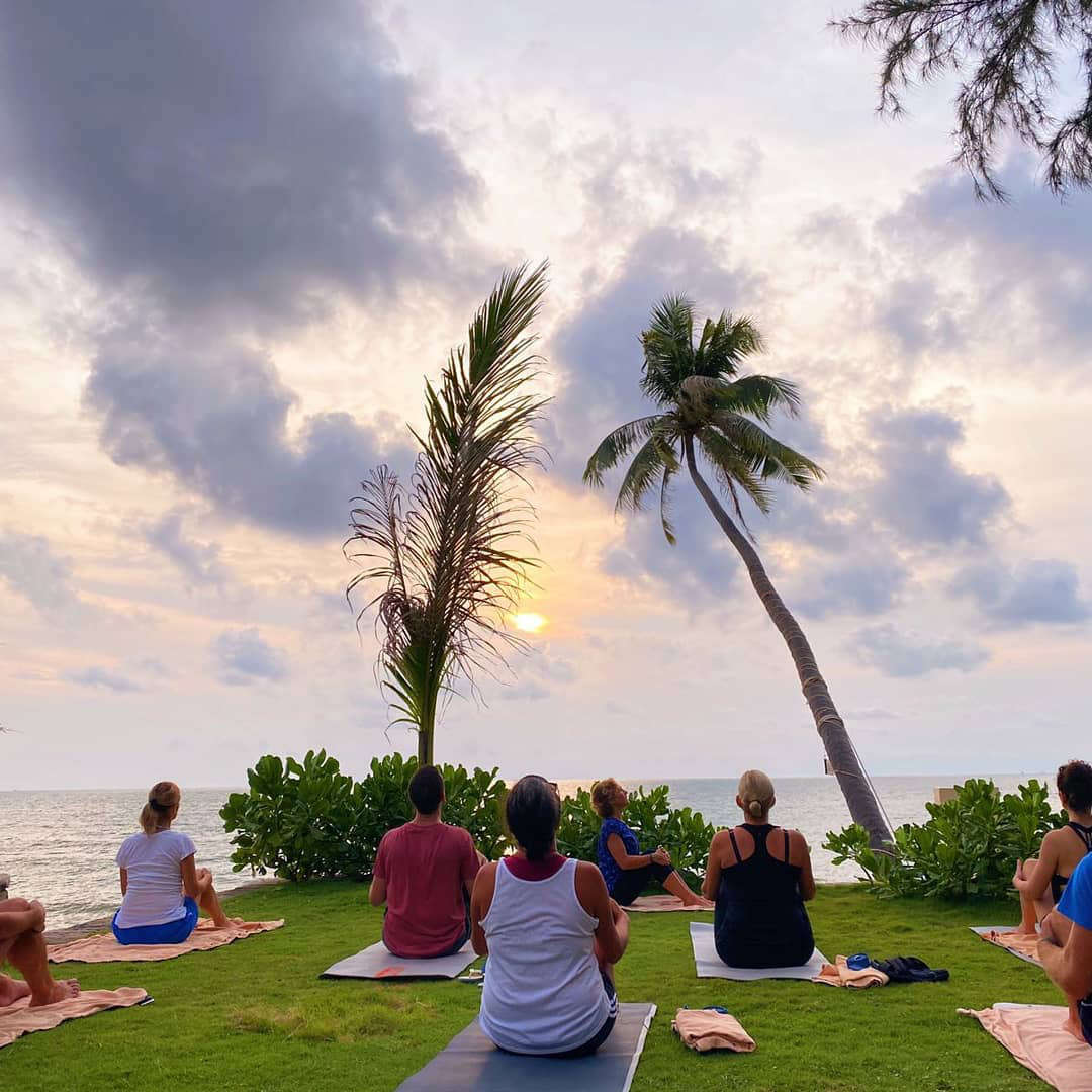 Hình ảnh một người đang tập yoga tại resort wellness với không gian xanh, yên tĩnh