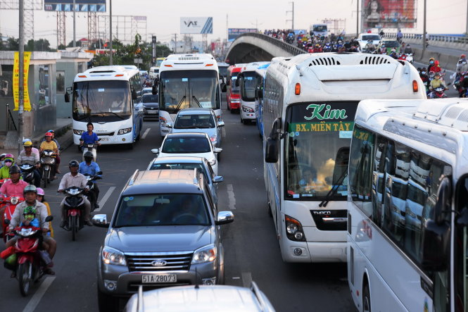 
Ô tô khách, xe máy ùn ứ kéo dài khu vực cầu vượt Nguyễn Văn Linh - Ảnh: HỮU KHOA
