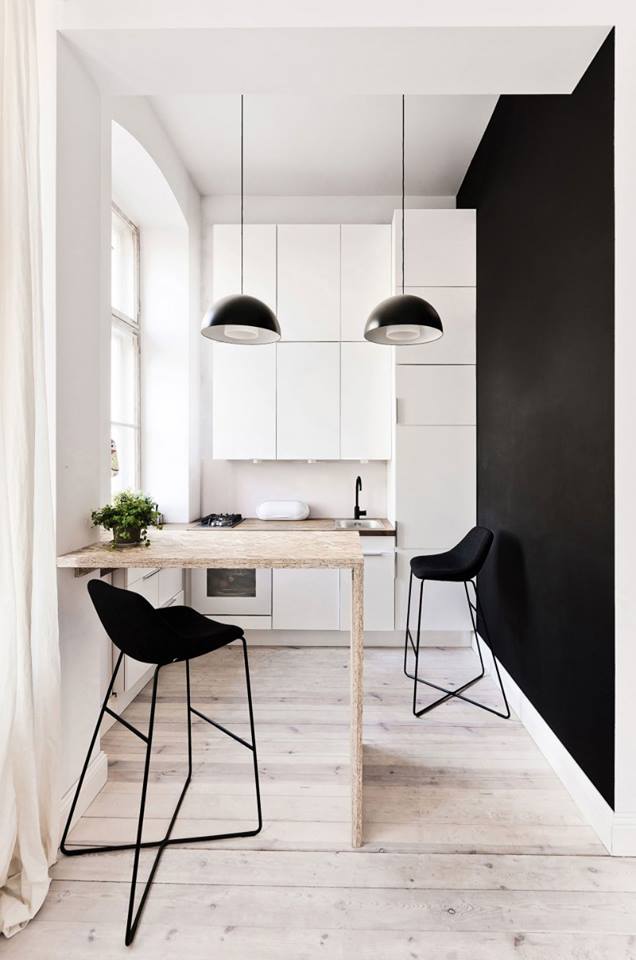 Khu vực bếp ăn thoáng sạch được bố trí kín đáo bên hông nhà. Một bức tường đen tương phản tạo không gian đặc biệt cho phòng bếp.