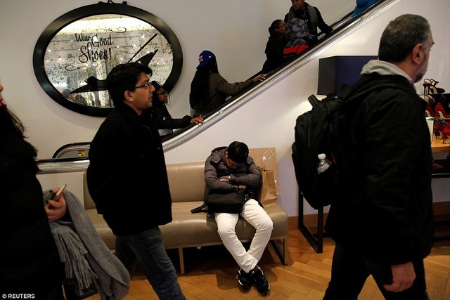 
Một người đàn ông ngủ gục trên ghế tại trung tâm thương mại Macy tối hôm qua. Ảnh: Reuters.
