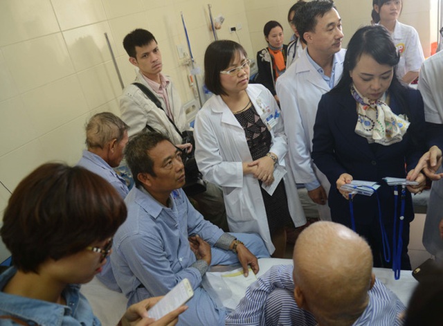 Bộ trưởng Bộ Y tế Nguyễn Thị Kim Tiến (bìa phải) lắng nghe ý kiến bệnh nhân trong chuyến thị sát Bệnh viện