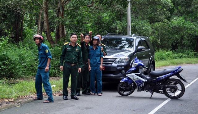 Nhóm của Đại tá Phạm Phú Ý chờ trao đổi với những người đi rừng về dấu vết máy bay không - Ảnh: Đông Hà