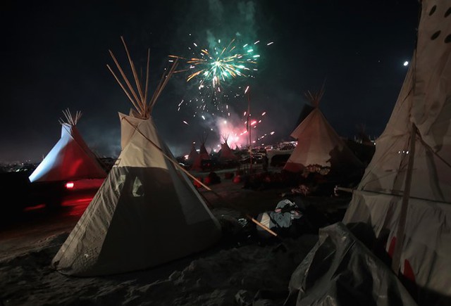Pháo hoa bắn lên từ khu trại của những người biểu tình chống đường ống dẫn dầu chạy qua Khu bảo tồn Standing Rock (bang North Dakota và South Dakota, Mỹ). Sau nhiều tháng dài các bộ lạc Da Đỏ, cựu binh và nhà hoạt động môi trường cắm trại biểu tình, hôm 5/12, Công binh Lục quân Mỹ - cơ quan quản lý các dự án xây dựng công cộng - đã từ chối cấp phép dự án này. Ảnh: Getty.