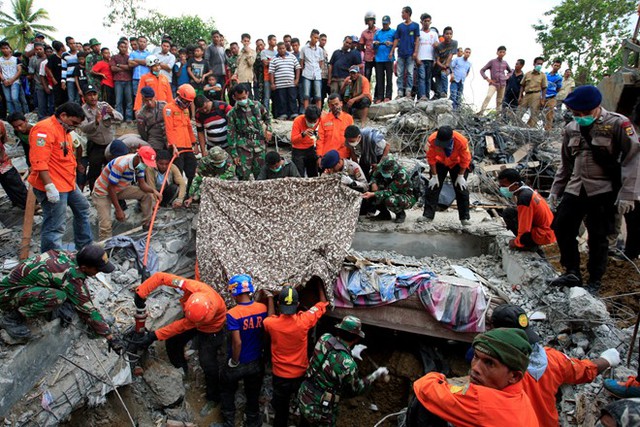 Quân đội và lực lượng cứu hộ Indonesia đang tìm kiếm người sống sót trong đống đổ nát ở thị trấn Lueng Putu, tỉnh Aceh hôm 7/12. Trận động đất 6,5 độ Richter xảy ra ở tỉnh Aceh đã khiến ít nhất 97 người thiệt mạng. Ảnh: Getty.