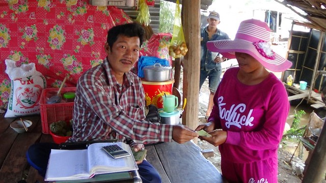 
Anh Trung trả tiền cua cho một người Campuchia vừa cân xong- Ảnh:;BỬU ĐẤU
