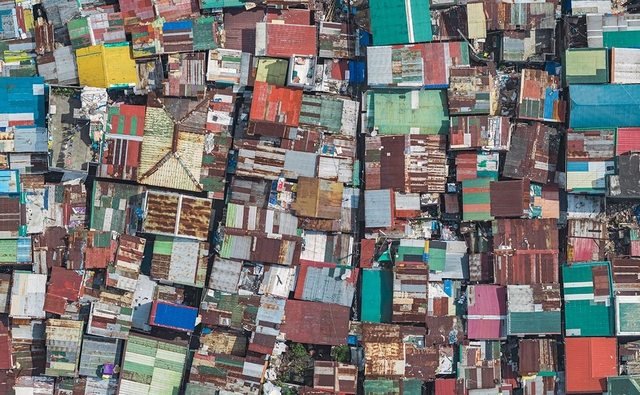 
Nhiếp ảnh gia Bernhard Lang chụp bộ ảnh về cuộc sống ở khu ổ chuột thể hiện sự quan tâm của ông tới một trong những vấn đề khẩn cấp nhất của toàn thế giới: bùng nổ dân số. Những mái nhà được lợp bằng vật liệu rẻ tiền, phế liệu nhiều màu sắc khiến người xem gợi nhớ tới các bức tranh theo trường phái trừu tượng.
