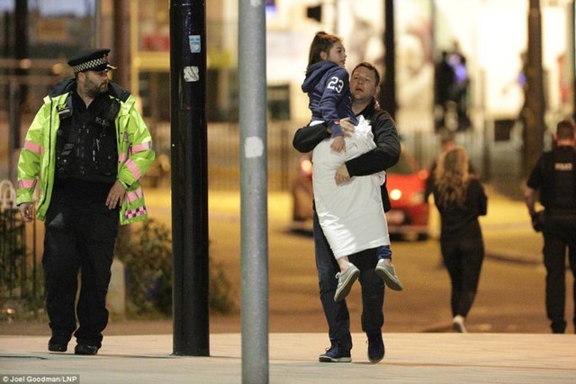 Một người cha bế con gái sau khi xảy ra vụ đánh bom khủng bố tại buổi hòa nhạc Ariana Grande. Ảnh: LNP.
