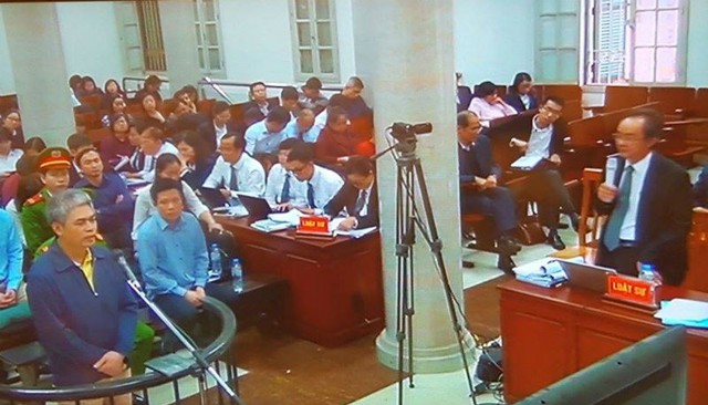 
Nguyễn Xuân Sơn (trái) đang trả lời các câu hỏi của Luật sư bào chữa cho mình chiều 06/03.
