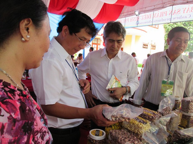 Ông Vũ Thái Sơn (thứ 2 từ trái sang) tìm hiểu các sản phẩm điều Bình Phước được giới thiệu tại hội nghị.