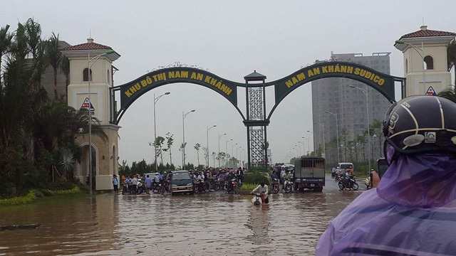 
Nước ngập sâu tại đường Lê Trọng Tấn - lối vào khu đô thị Nam An Khánh sau cơn mưa vào sáng 25/5/2016 (Ảnh Dân Trí).
