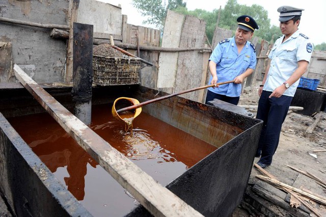 Cảnh sát kiểm tra dầu ăn bất hợp pháp, hoặc dầu rãnh, bị tịch thu trong một cuộc truy quét ở Bắc Kinh vào tháng 8/2010